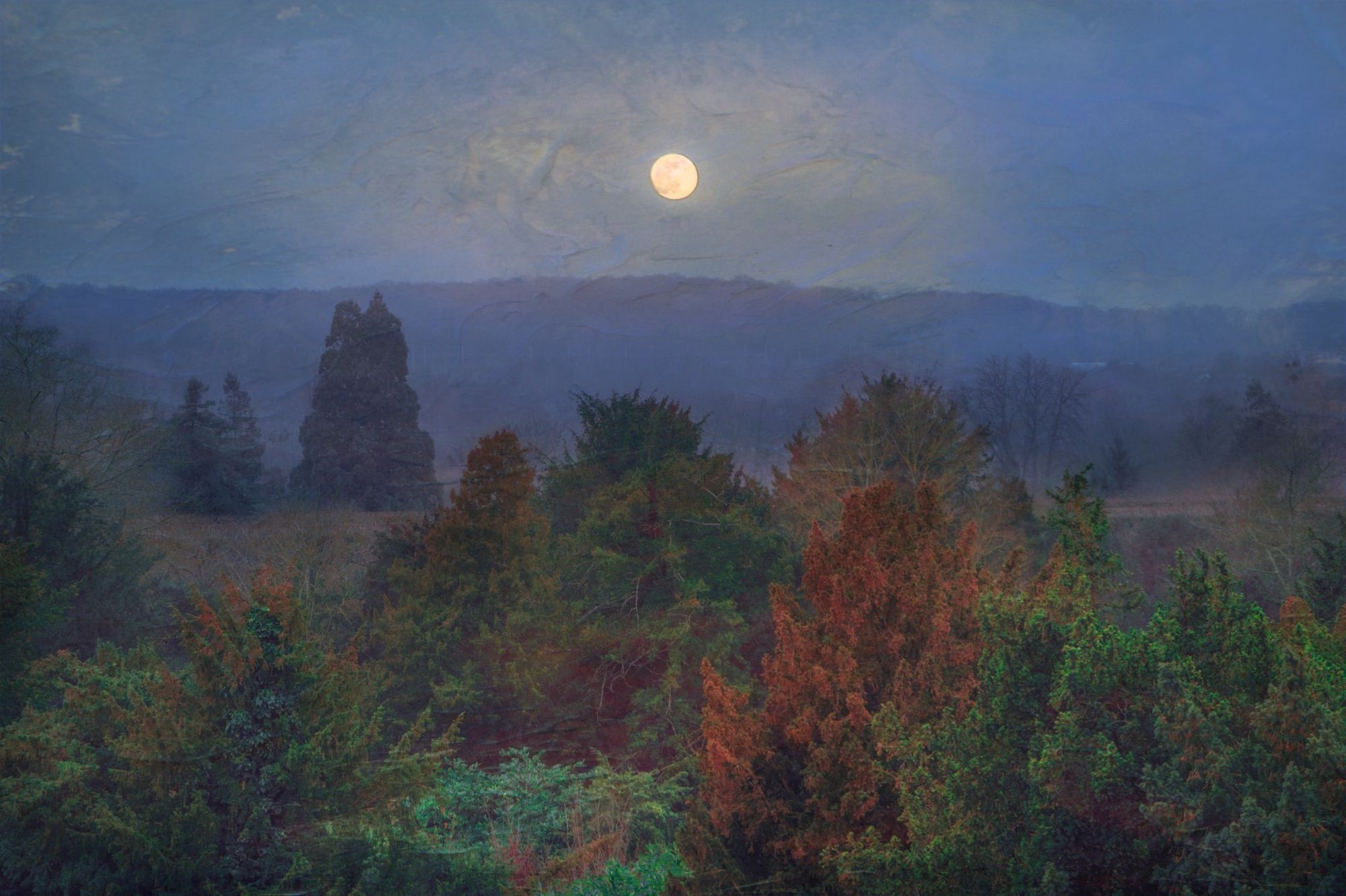 moody image of the moon over trees, with fall color, against a distant blue mountain… it's clearly not a single photograph and has a texture like an oil painting
